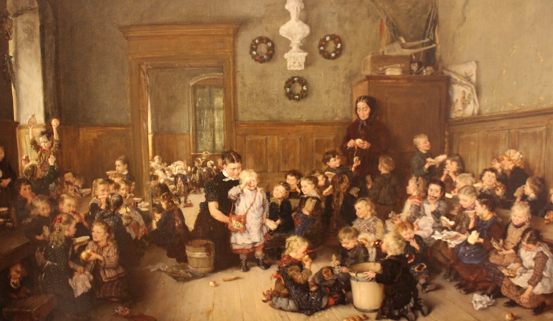Pintura de un kínder del siglo XIX: dos maestras entre decenas de niños que desayunan en el piso de madera